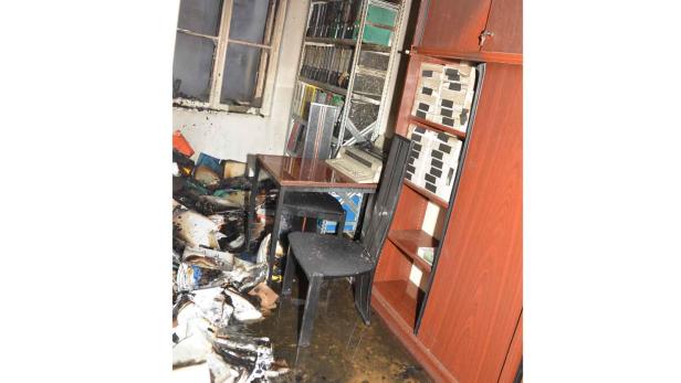 Ein Büro nach einem Brand mit verbrannten Dokumenten und Möbeln.