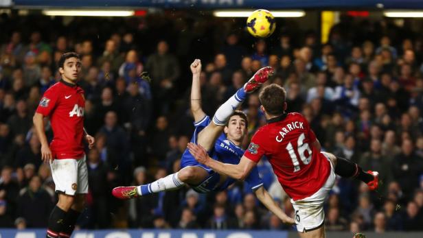 Ein Fußballspieler versucht, den Ball mit einem Fallrückzieher zu spielen.
