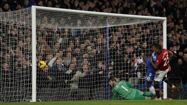 Ein Fußball fliegt ins Tor, während ein Torwart am Boden liegt und zwei Spieler kämpfen.