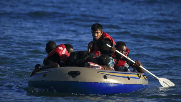 Mehrere Personen in einer kleinen Schlauchboot auf dem offenen Meer.