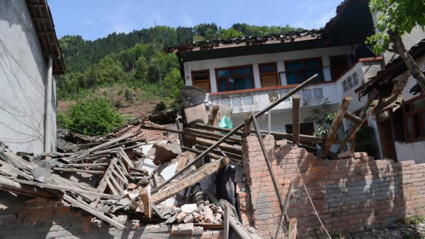 Ein durch ein Erdbeben beschädigtes Haus mit Trümmern und freiliegenden Ziegeln.