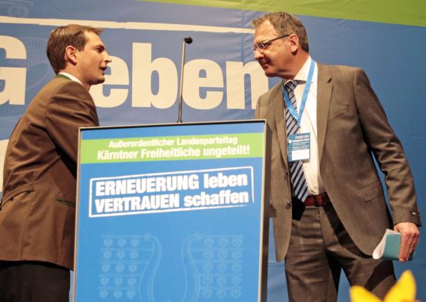 Zwei Männer stehen an einem Rednerpult der Kärntner Freiheitlichen.