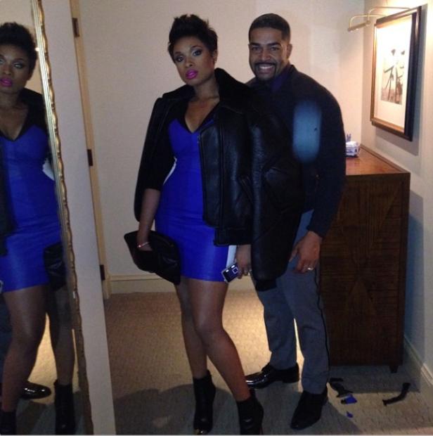 Jennifer Hudson posiert mit einem Mann in einem blauen Kleid und einer Lederjacke.