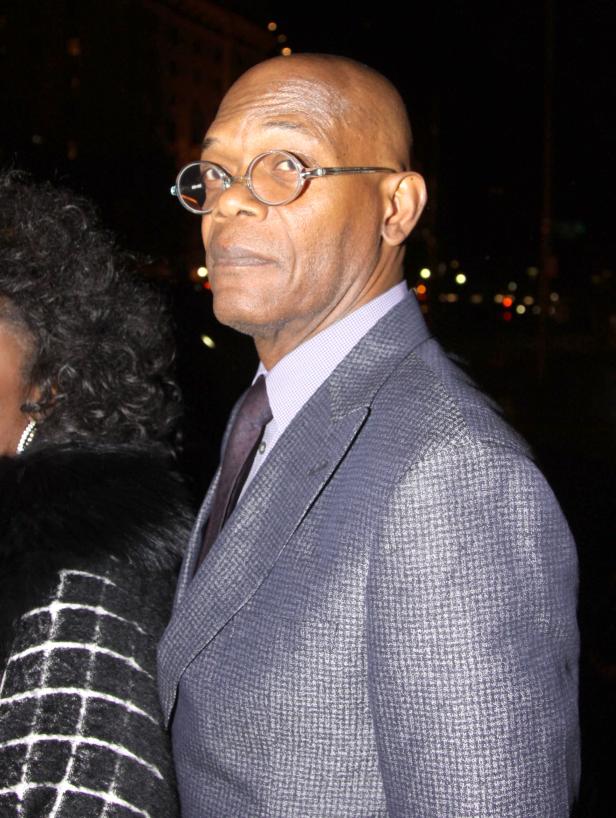 Samuel L. Jackson mit runder Brille und Anzug blickt über die Schulter.