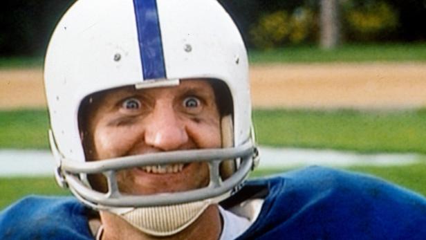 Ein Footballspieler mit Helm und blauem Trikot blickt mit aufgerissenen Augen in die Kamera.