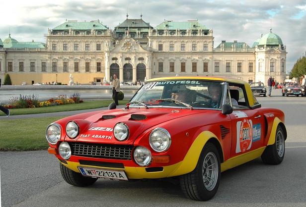 Ein roter Fiat Abarth Rallyewagen vor dem Schloss Schönbrunn in Wien.