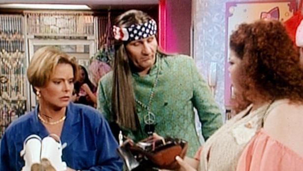 Drei Personen in einem Laden, eine davon im Hippie-Stil gekleidet.