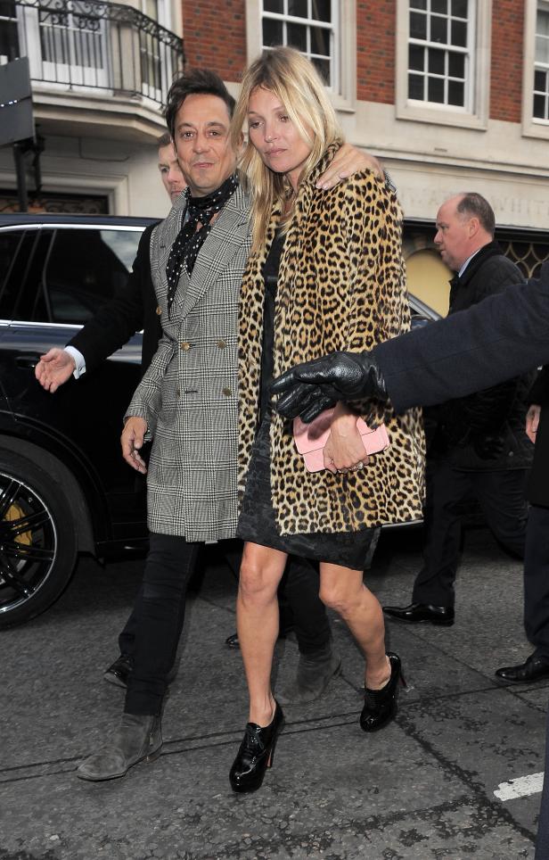 Kate Moss mit einem Freund in einem Leopardenmantel auf der Straße.