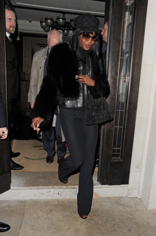 Naomi Campbell verlässt ein Gebäude in einem schwarzen Outfit.