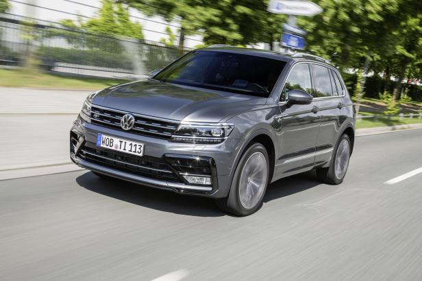 Ein grauer VW Tiguan fährt auf einer asphaltierten Straße.
