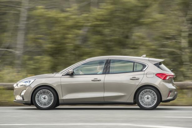 Ein beiger Ford Focus fährt auf einer Landstraße.