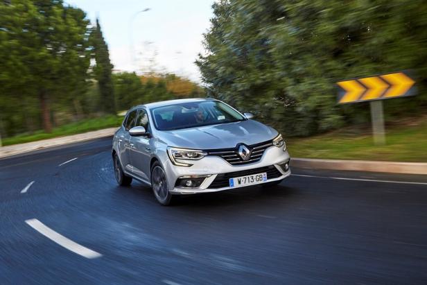 Ein silberner Renault Mégane fährt auf einer kurvenreichen Straße.