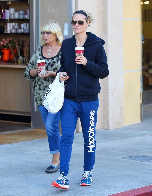 Heidi Klum mit einer Begleiterin beim Verlassen eines Geschäfts mit Kaffee in der Hand.