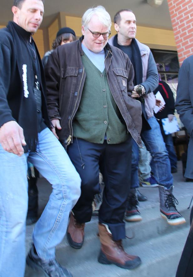 Philip Seymour Hoffman mit anderen Personen im Freien.