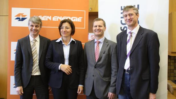 Vier Personen posieren vor einem Banner von Wien Energie.
