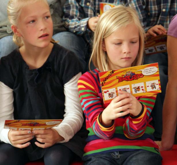 Zwei Mädchen lesen Bücher der „Tom Turbo“-Reihe von Thomas Brezina.