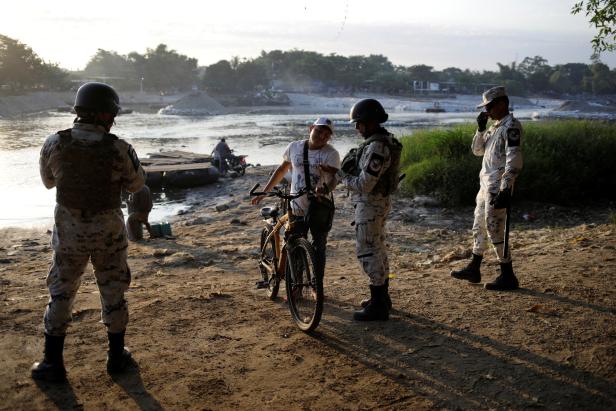 Members of Mexican security forces checks documents of people crossing the river Suchiate in Ciudad Hidalgo