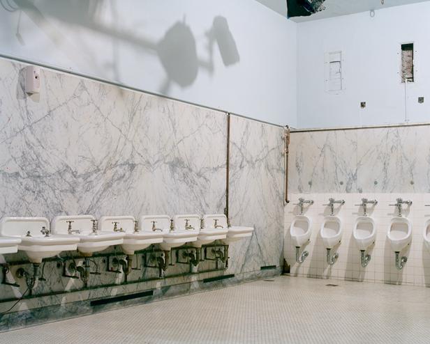 Ein öffentliches Badezimmer mit mehreren Waschbecken und Urinalen.