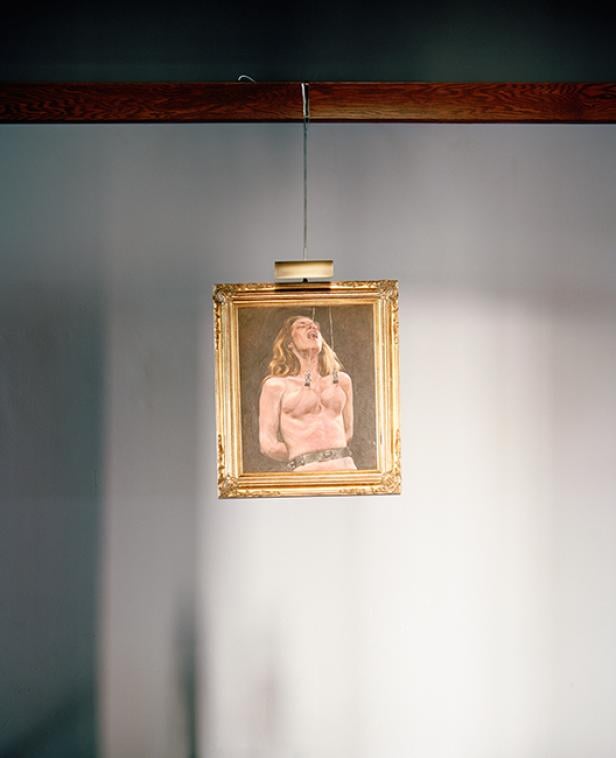 Ein Gemälde mit goldenem Rahmen zeigt eine gefesselte Frau.