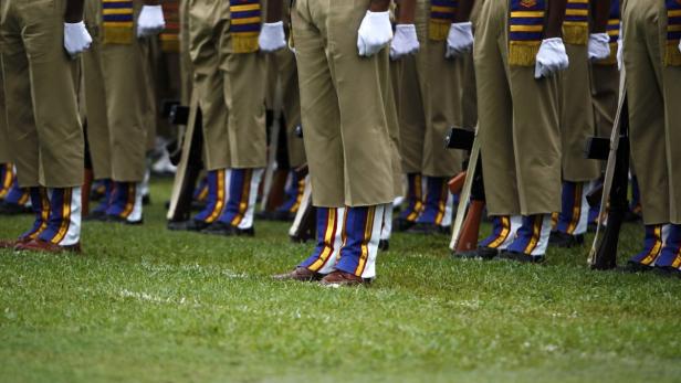 Eine Reihe von Soldaten in Uniform stehen auf einem Rasen.