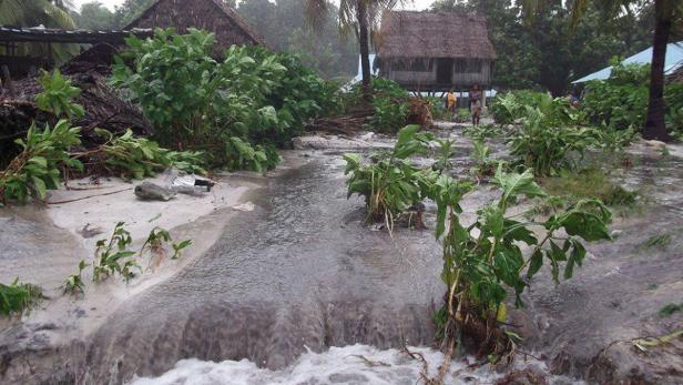 Hochwasser hat ein Dorf mit Häusern auf Stelzen überschwemmt.