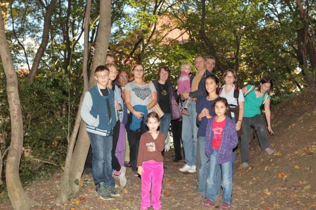 Eine Gruppe von Menschen steht in einem Waldstück.