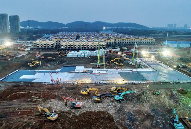 Excavators and workers are seen at the construction site where the new Huoshenshan Hospital is being built to treat patients of a new coronavirus on the outskirts of Wuhan