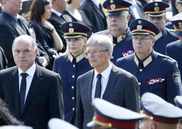 Eine Gruppe von Personen, darunter mehrere in Polizeiuniformen, bei einer formellen Veranstaltung.