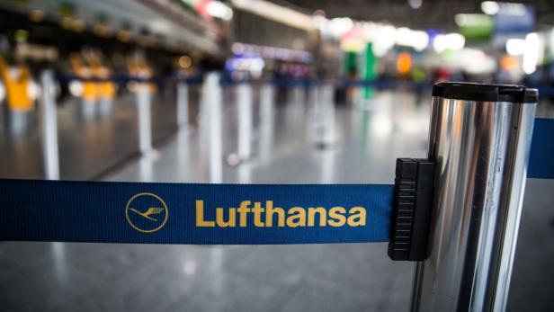 Ein blaues Absperrband mit dem Lufthansa-Logo in einem Flughafen.