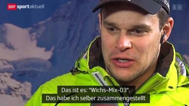 Ein Mann in Sportkleidung spricht vor einer Bergkulisse.