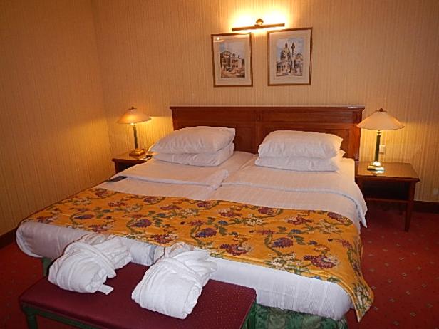 Ein Hotelzimmer mit einem Doppelbett und zwei Bademänteln.