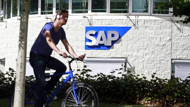 Ein Mann fährt mit dem Fahrrad vor einem SAP-Gebäude.