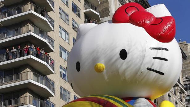 Ein riesiger Hello-Kitty-Ballon bei einer Parade in einer Stadt.