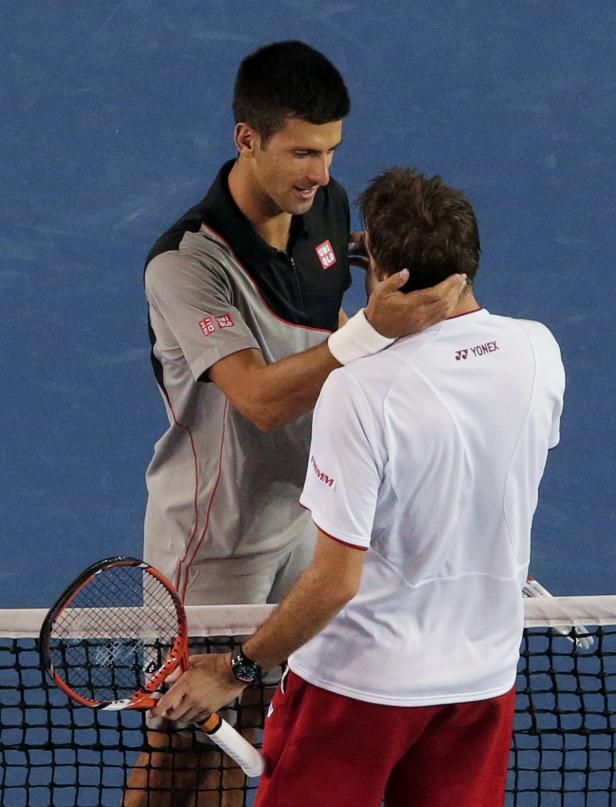 Novak Đoković tröstet einen anderen Tennisspieler am Netz.