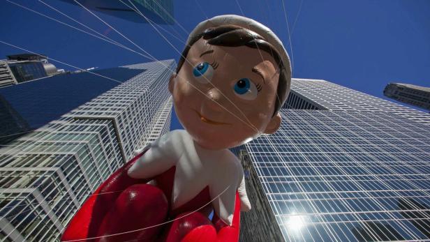 Ein „Elf on the Shelf“-Ballon schwebt vor Wolkenkratzern.