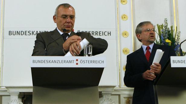Zwei Männer stehen an Rednerpulten mit der Aufschrift „Bundeskanzleramt Österreich“.