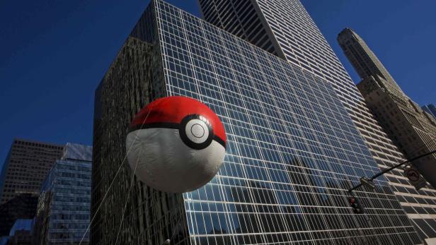 Ein Pokémon-Ball-Ballon schwebt vor modernen Bürogebäuden.