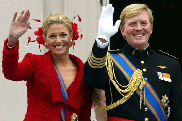 König Willem-Alexander und Königin Máxima winken lächelnd in die Menge.
