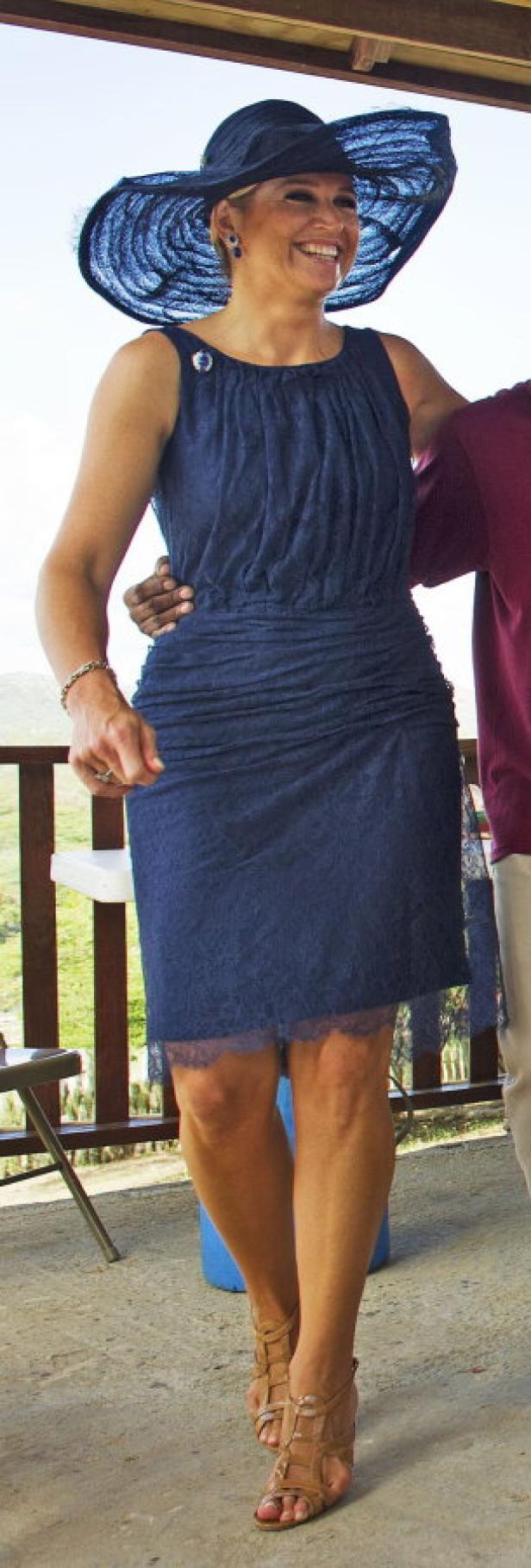 Königin Máxima trägt ein blaues Kleid und einen passenden Hut.