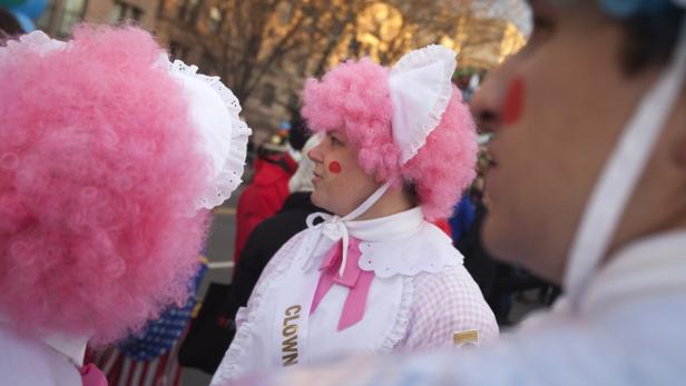 Zwei als Clowns verkleidete Personen mit rosa Perücken und weißer Kleidung.