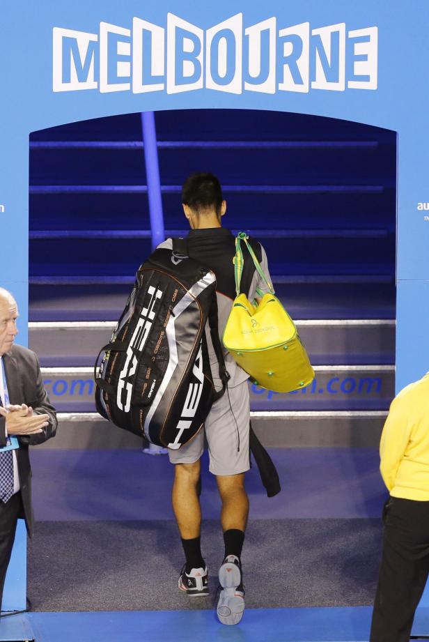 Ein Tennisspieler mit Taschen betritt das Gelände der Australian Open in Melbourne.