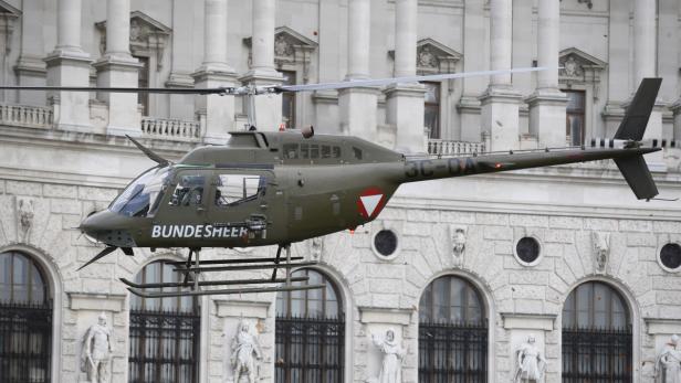 Ein Hubschrauber des Bundesheeres fliegt vor einem historischen Gebäude.