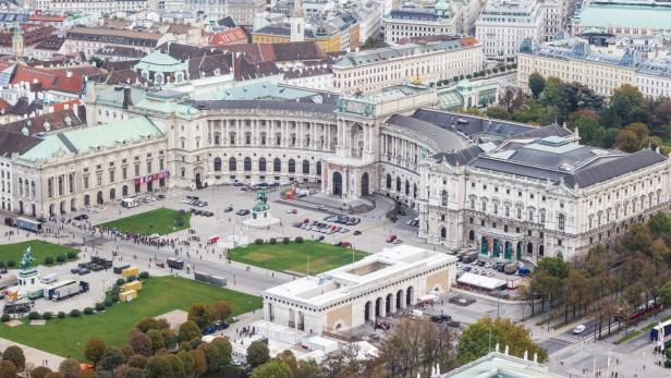Luftaufnahme der Hofburg in Wien mit Menschen und Fahrzeugen.