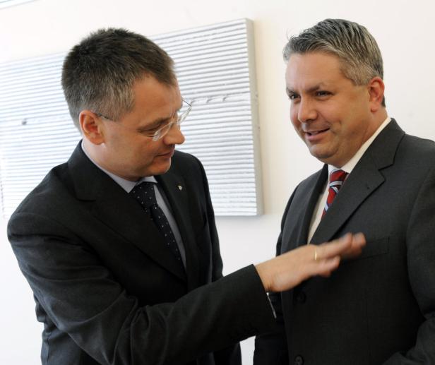 Zwei Männer in Anzügen unterhalten sich.