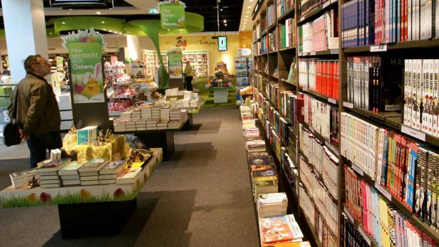 Ein Mann betrachtet in einer Buchhandlung einen Aufsteller mit Osterdekorationen.