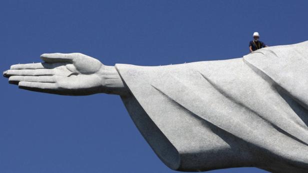 Ein Arbeiter steht auf dem Arm der Christusstatue in Rio de Janeiro.