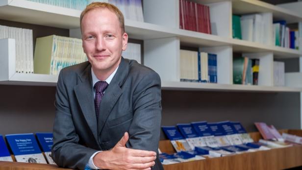 Guntram B. Wolff, Director Bruegel… Ein Mann im Anzug lehnt vor einem Bücherregal.