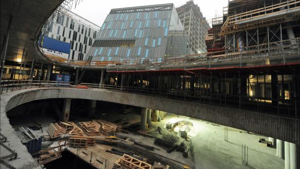 Eine Baustelle mit einem modernen Gebäude im Hintergrund.