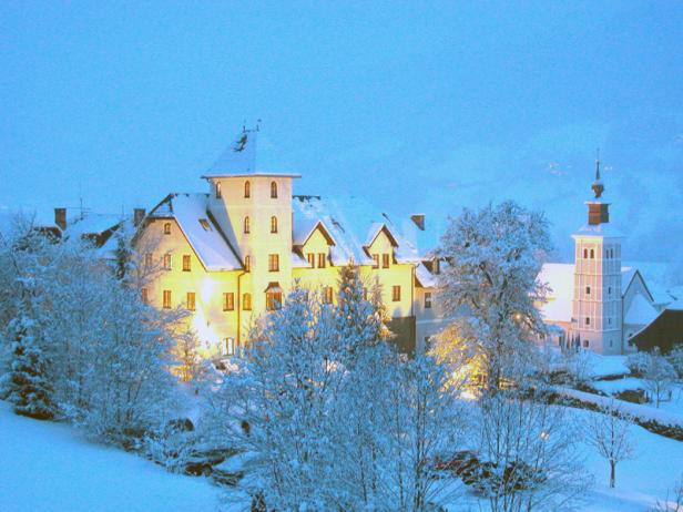 Ein Schloss und eine Kirche sind im Winter mit Schnee bedeckt.