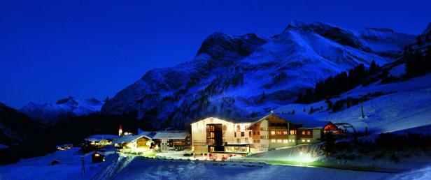 Das Sporthotel Steffisalp liegt in einer verschneiten Berglandschaft bei Nacht.